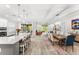 Open-concept living room and kitchen with a large island, modern lighting, and hardwood floors at 132 Rosa Bella Vw, Debary, FL 32713