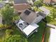 A high angle view of a home showing off its backyard pool, solar panels, and screened in porch at 13214 Triphammer Way, Orlando, FL 32828