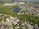 Aerial view highlights the property's proximity to a large pond and wooded area at 13214 Triphammer Way, Orlando, FL 32828