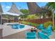 Backyard featuring a sparkling pool, lounge chairs, fire pit, string lights, and privacy fence at 13214 Triphammer Way, Orlando, FL 32828