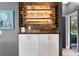 Charming bar area with rustic wood backdrop, illuminated shelves, and white cabinets at 13214 Triphammer Way, Orlando, FL 32828