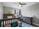 Bedroom features dinosaur decor, crib, area rug, and chair with natural light at 13214 Triphammer Way, Orlando, FL 32828