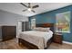 Bedroom with natural light, ceiling fan, ensuite bath, and wood-look floors at 13214 Triphammer Way, Orlando, FL 32828