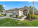 Beautiful one-story home with a well-maintained lawn and an inviting arched entryway at 13214 Triphammer Way, Orlando, FL 32828