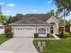 Charming single-Gathering home featuring a two-car garage and manicured landscaping at 13214 Triphammer Way, Orlando, FL 32828