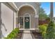 Welcoming front porch with a decorative wreath on the green front door and lush landscaping at 13214 Triphammer Way, Orlando, FL 32828
