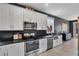 Kitchen featuring white cabinets, stainless steel appliances, and geometric backsplash at 13214 Triphammer Way, Orlando, FL 32828