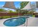 Backyard showcases a sparkling pool, shaded seating, and manicured landscaping at 13214 Triphammer Way, Orlando, FL 32828