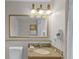 Bright bathroom featuring granite counters, decorative lighting, and a gold-trimmed mirror at 13415 Blue Heron Beach Dr # 208, Orlando, FL 32821
