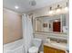 Well-lit bathroom with a combination tub and shower, vanity, and decorative pineapple lighting fixtures at 13415 Blue Heron Beach Dr # 208, Orlando, FL 32821