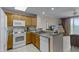 Kitchen features white appliances, tile flooring and wood cabinetry at 13415 Blue Heron Beach Dr # 208, Orlando, FL 32821