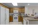 Kitchen featuring white appliances, wood cabinets and granite counters at 13415 Blue Heron Beach Dr # 208, Orlando, FL 32821