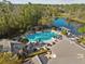 This aerial showcases a community pool, pond, and clubhouse framed by lush greenery, perfect for relaxation at 14090 Avenue Of The Groves, Winter Garden, FL 34787