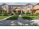Charming townhome exterior with lush green landscaping, a well-maintained lawn, and welcoming front entrances at 14090 Avenue Of The Groves, Winter Garden, FL 34787