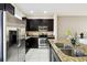 Modern kitchen featuring stainless steel appliances, granite countertops, and dark wood cabinetry at 14090 Avenue Of The Groves, Winter Garden, FL 34787