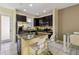 Stylish kitchen with granite island, stainless steel appliances, and dark cabinets at 14090 Avenue Of The Groves, Winter Garden, FL 34787