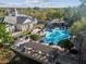 Aerial view showcases a pool and amenity center, with lounge seating and lush landscaping for community enjoyment at 14090 Avenue Of The Groves, Winter Garden, FL 34787