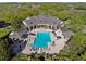 Aerial view of a community pool with lounge chairs, shade, and a building with a covered patio at 14090 Avenue Of The Groves, Winter Garden, FL 34787