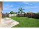 Spacious backyard features a well-maintained lawn, privacy fence, and a concrete patio area at 1413 Timberbend Cir, Orlando, FL 32824