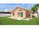 Exterior shot of the rear of the home, featuring a well-kept lawn and back patio at 1413 Timberbend Cir, Orlando, FL 32824