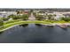 Gorgeous aerial view featuring a pier on a lake with lush trees, palm trees, and neighborhood buildings at 1425 Chatfield Pl, Orlando, FL 32814