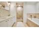 Bright bathroom featuring dual sinks, tile accent wall, walk-in shower, and bathtub at 1425 Chatfield Pl, Orlando, FL 32814