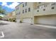 Townhomes featuring attached garages with light yellow exterior paint, and well-maintained asphalt driveway at 1425 Chatfield Pl, Orlando, FL 32814