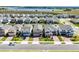 An aerial view of a street with houses and a lake in the distance at 14613 Erice Ave, Clermont, FL 34714