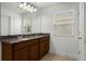 Bright bathroom featuring double vanity with granite countertop and a large mirror at 14613 Erice Ave, Clermont, FL 34714