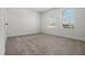Bright bedroom featuring neutral carpet and two windows providing ample natural light at 14613 Erice Ave, Clermont, FL 34714