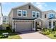 Two-story house with brick driveway, attached garage, and a front yard at 14613 Erice Ave, Clermont, FL 34714