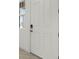 A modern white front door is accented by a digital lock and window at 14613 Erice Ave, Clermont, FL 34714