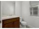 A well-lit powder room features a dark vanity and a white toilet at 14613 Erice Ave, Clermont, FL 34714