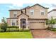 Charming home featuring a two-car garage, manicured lawn, and a stone and stucco exterior at 1518 Rolling Fairway Dr, Davenport, FL 33896