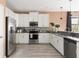 Well-lit kitchen featuring stainless steel appliances, granite countertops, and white cabinetry at 1518 Rolling Fairway Dr, Davenport, FL 33896