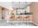 Open kitchen with bar stool seating, white cabinets, stainless steel appliances, and sleek pendant lights at 1518 Rolling Fairway Dr, Davenport, FL 33896