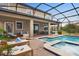 Beautiful outdoor pool area with a screened-in patio, lounge chairs, and manicured landscaping at 1518 Rolling Fairway Dr, Davenport, FL 33896