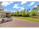 Spacious backyard featuring a brick patio, green lawn, mature trees, and a playground at 1559 Scrub Jay Ct, Deland, FL 32724