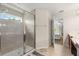 Walk-in shower with tiled walls adjacent to wood cabinets and dual sinks at 1559 Scrub Jay Ct, Deland, FL 32724