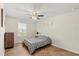 Cozy bedroom featuring a ceiling fan, warm-toned flooring, and a comfy bed by the window at 1559 Scrub Jay Ct, Deland, FL 32724