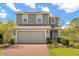 Charming two-story home featuring a spacious two-car garage, brick paved driveway, and professionally landscaped yard at 1559 Scrub Jay Ct, Deland, FL 32724