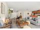 Bright living room featuring plush seating, decorative shelving, and view into kitchen with breakfast bar at 1559 Scrub Jay Ct, Deland, FL 32724