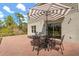 Outdoor patio area with brick pavers, seating, and a large umbrella for shade at 1559 Scrub Jay Ct, Deland, FL 32724