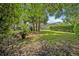 Spacious backyard features manicured lawn, mature trees, and a charming patio area for outdoor living at 1621 Highland Dr, Longwood, FL 32750