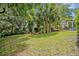 Beautiful backyard features lush green lawn, mature trees, and a quaint seating area at 1621 Highland Dr, Longwood, FL 32750