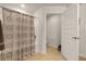 Bathroom featuring a tub-shower combo with patterned shower curtain and an open door at 1645 Denali St, Davenport, FL 33837