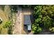 An aerial view shows the home with a dark roof and a concrete driveway nestled on a tree-lined lot at 170 Blaine St, Eustis, FL 32726