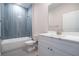 Bright bathroom with marble countertop, white cabinets, and tile shower at 170 Blaine St, Eustis, FL 32726
