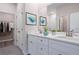 Bathroom with double sinks, white cabinets, and a large mirror with decor at 170 Blaine St, Eustis, FL 32726