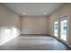 Spacious, empty living room with neutral walls, modern floors, and double doors to the outside at 170 Blaine St, Eustis, FL 32726